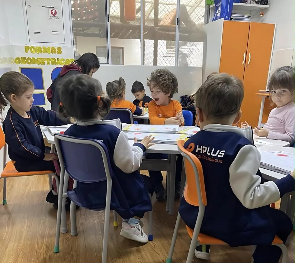 Turma da Educação Infantil em atividade na sala, em volta das mesas